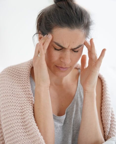 Woman holding her temples in pain needing migraine treatment in Brookfield