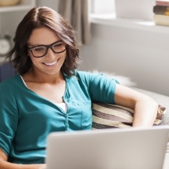 Woman on couch looking at laptop