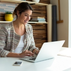 Woman sitting at desk typing on laptop