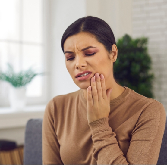 Woman holding her jaw in pain needing T M J treatment in Brookfield