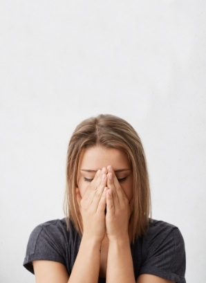 Woman holding her face in her hands