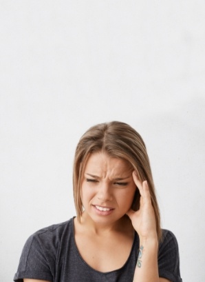 Woman wincing and touching the side of her head