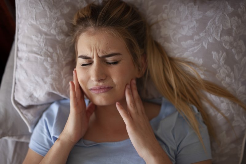 Woman in bed with jaw pain