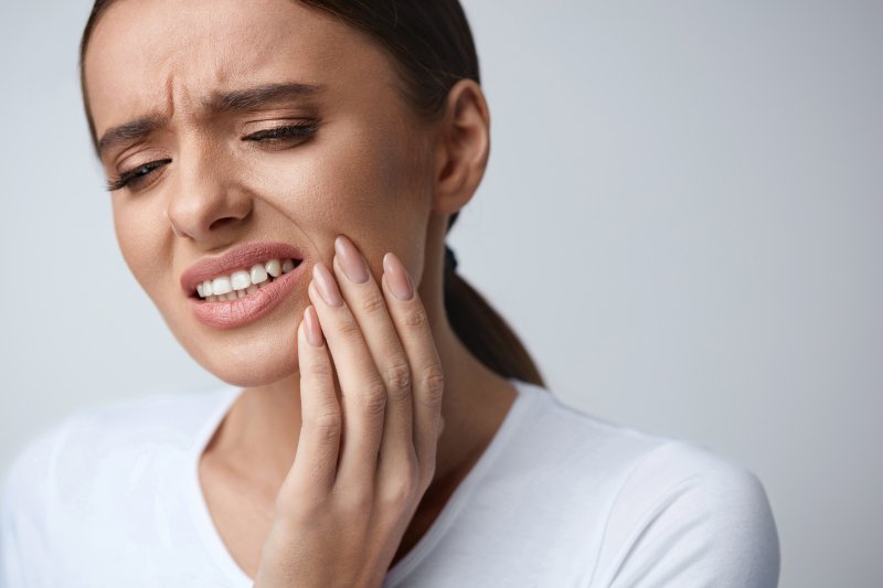 person holding their jaw 