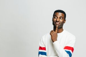 Man wearing curious expression while touching his chin